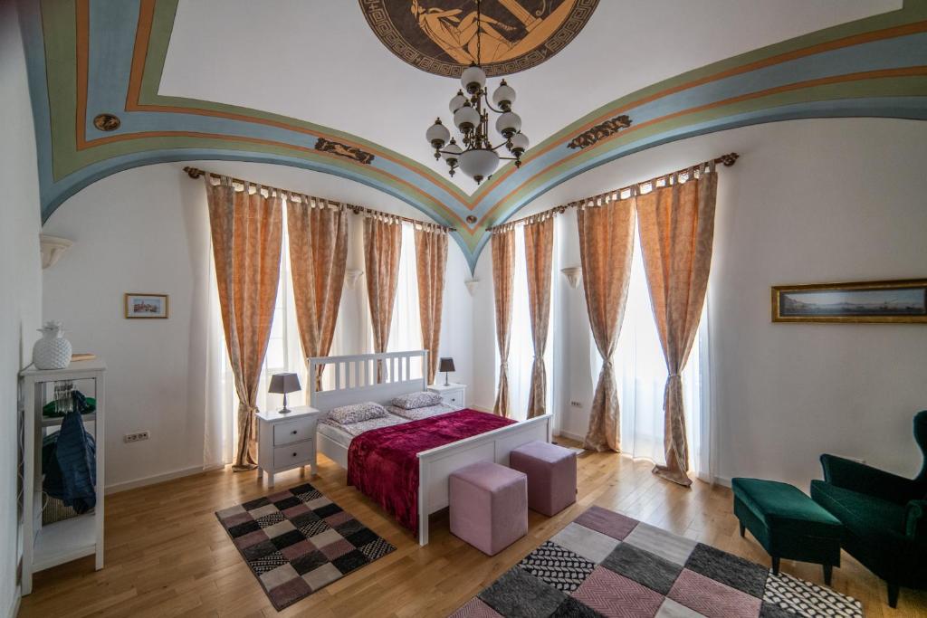 ein Schlafzimmer mit einem Bett in einem Zimmer mit Fenstern in der Unterkunft City Park Apartments in Timişoara
