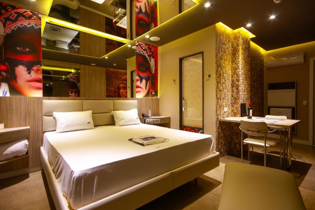 um quarto de hotel com uma cama e um bar em Motel Golf (Adult Only) em Osasco