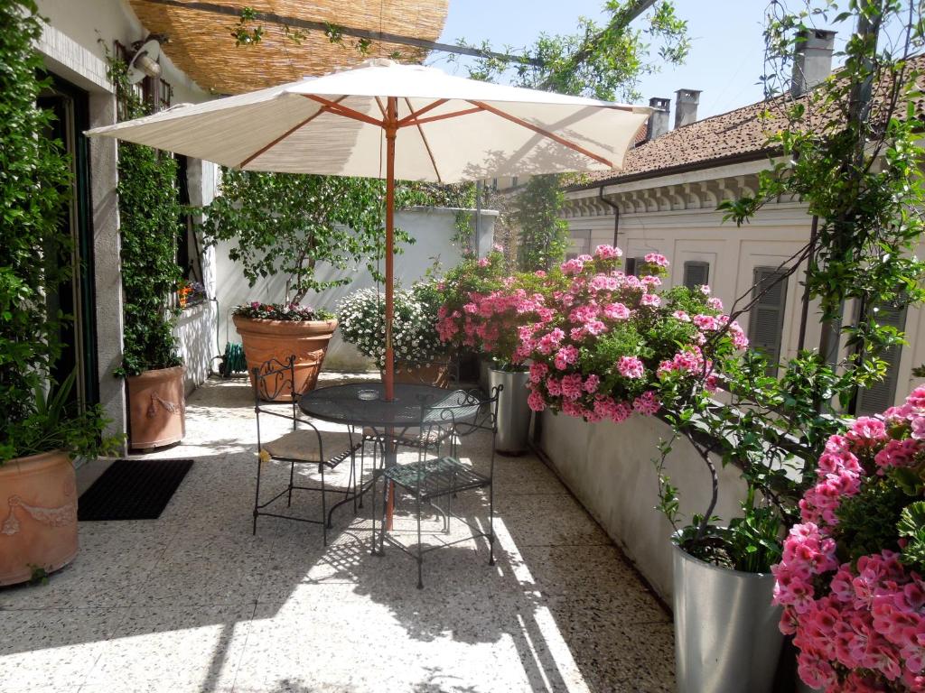 un patio con tavolo, sedie e fiori di Antica Locanda Dei Mercanti a Milano