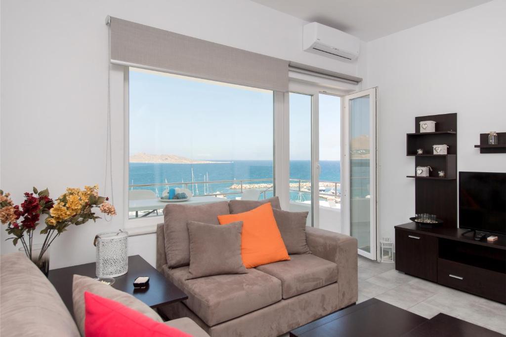 a living room with a couch and a large window at Ormos Naoussa's suite in Naousa