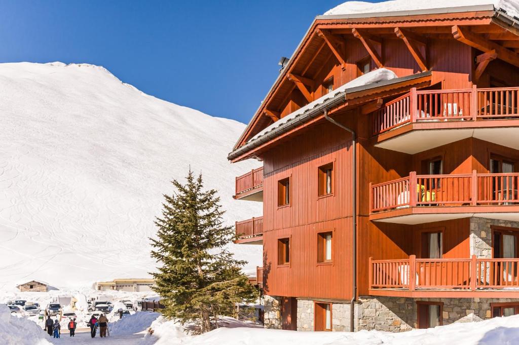 un lodge de ski dans la neige à côté d'une montagne dans l'établissement Residence l'Ecrin des Neiges - maeva Home, à Tignes