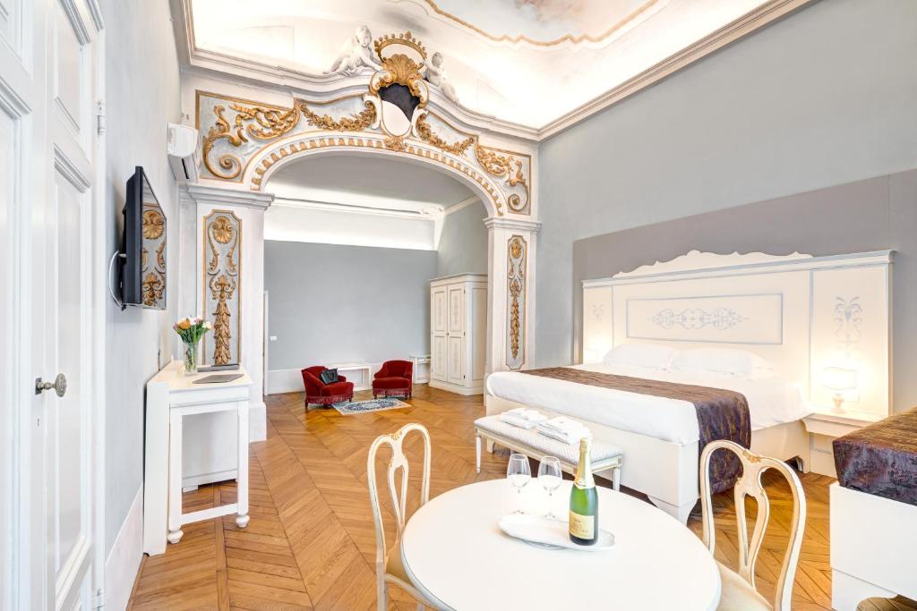 a bedroom with a bed and a table and chairs at Palazzo D'Oltrarno - Residenza D'Epoca in Florence