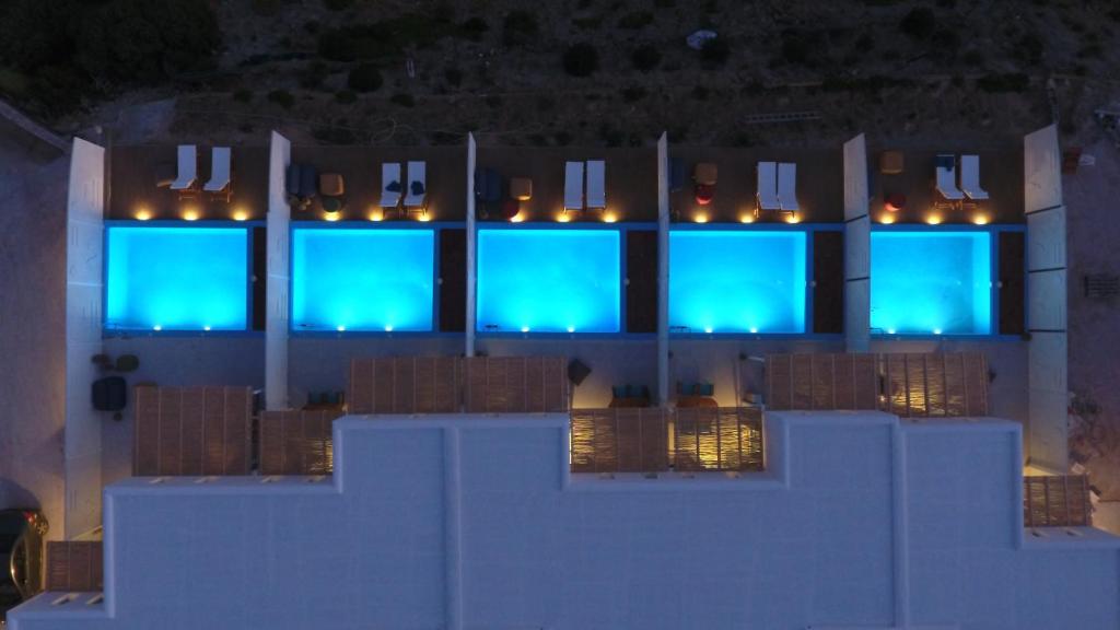 un edificio con ventanas azules con luces encendidas en Aelia Collection Suites - Adults Friendly, en Skiros