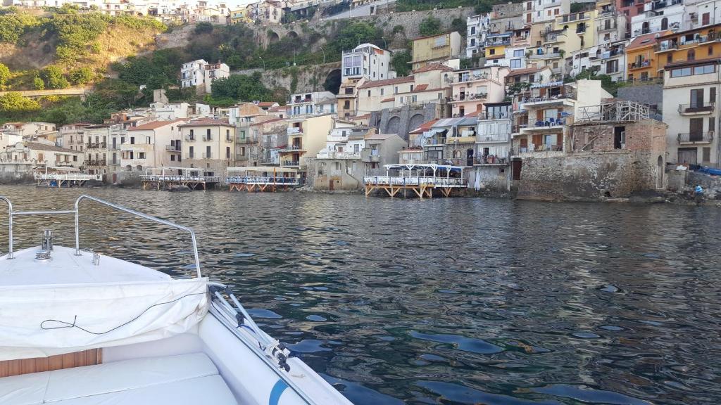 a boat in a body of water with buildings at SeaSide rooms in Scilla