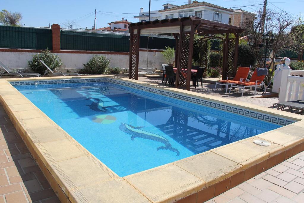 a swimming pool in a backyard with a gazebo at Casa Flamenca en El Ventorrillo - Piscina, Tumbonas, Terraza y Aparcamiento in Cúllar-Vega