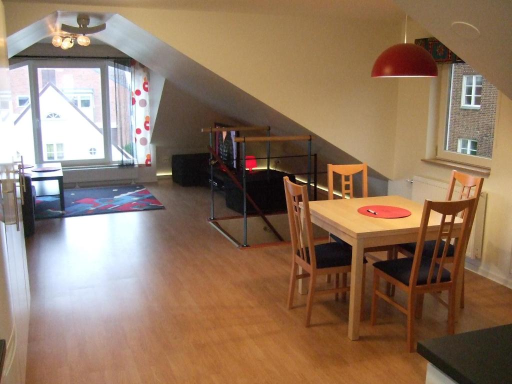 salon ze stołem, krzesłami i schodami w obiekcie Honeymoon Seaview Apartment w mieście Helsingborg