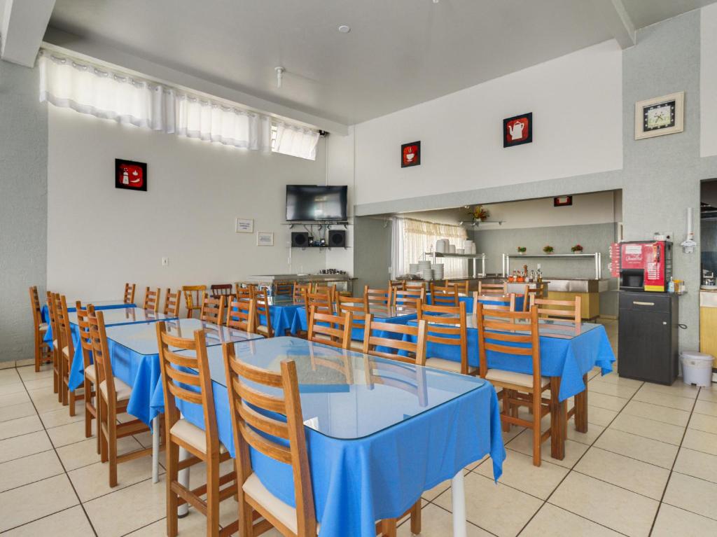 a dining room with blue tables and chairs at Teuthos Hotel in Teutônia