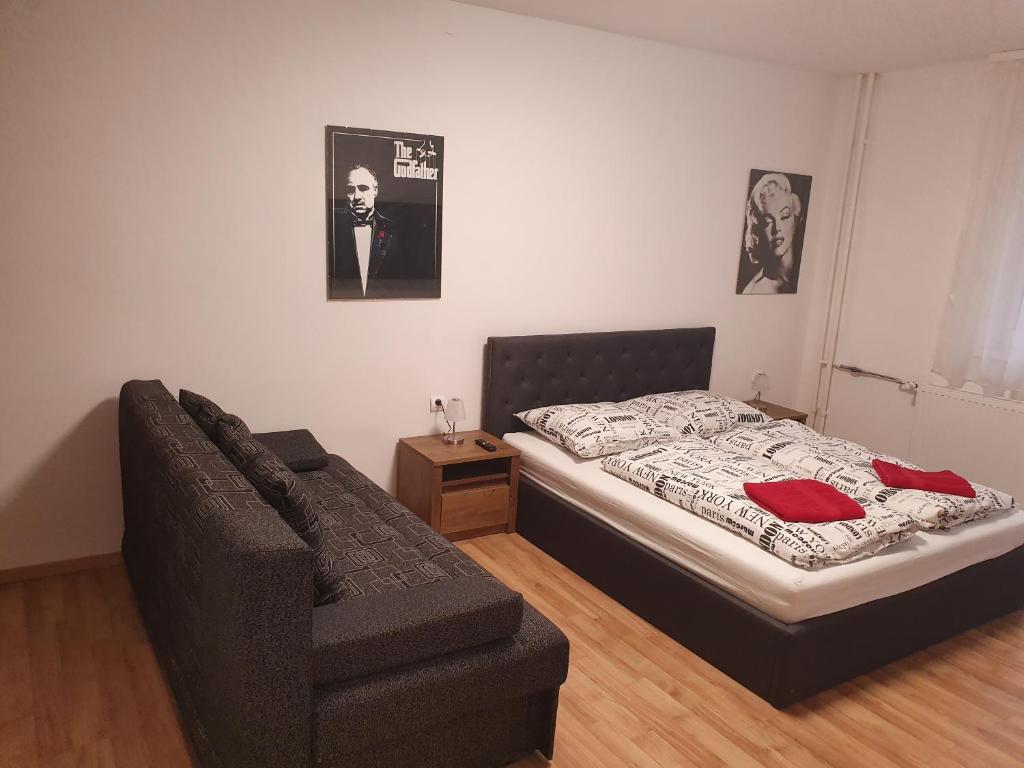 1 dormitorio con 1 cama y 1 sofá en Komfort apartman, en Veszprém