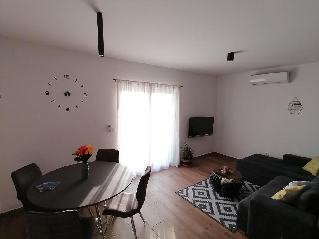 uma sala de estar com uma mesa e um relógio na parede em Apartments Jakov em Makarska