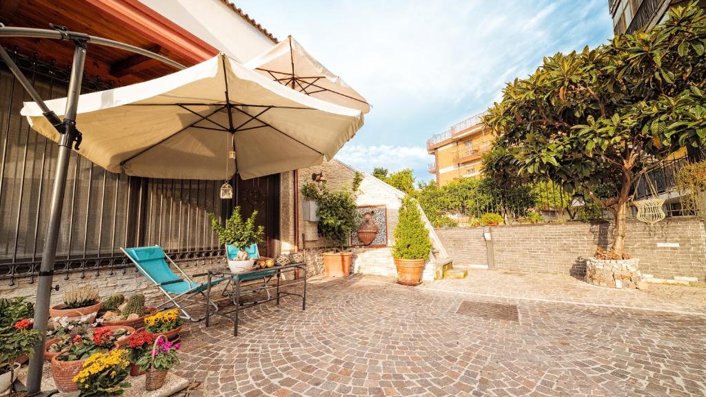 een patio met een parasol, een tafel en een stoel bij B&B La Casa Di Plinio in Pompei