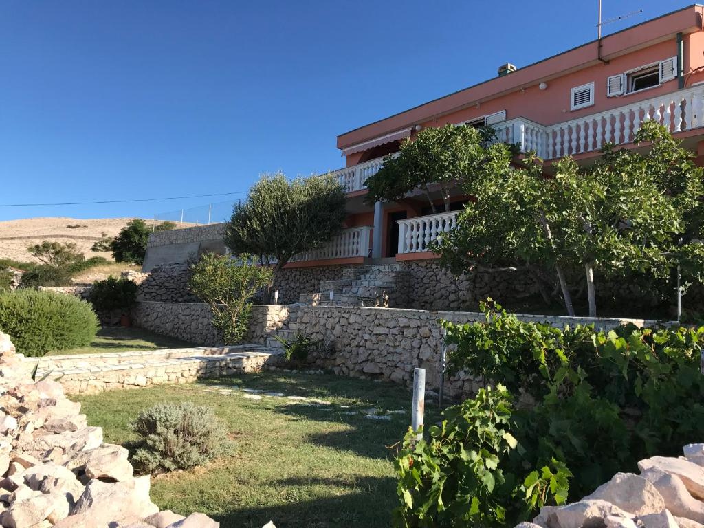 a house with a stone wall and trees in front of it at Holiday Home Panorama in Zubovići