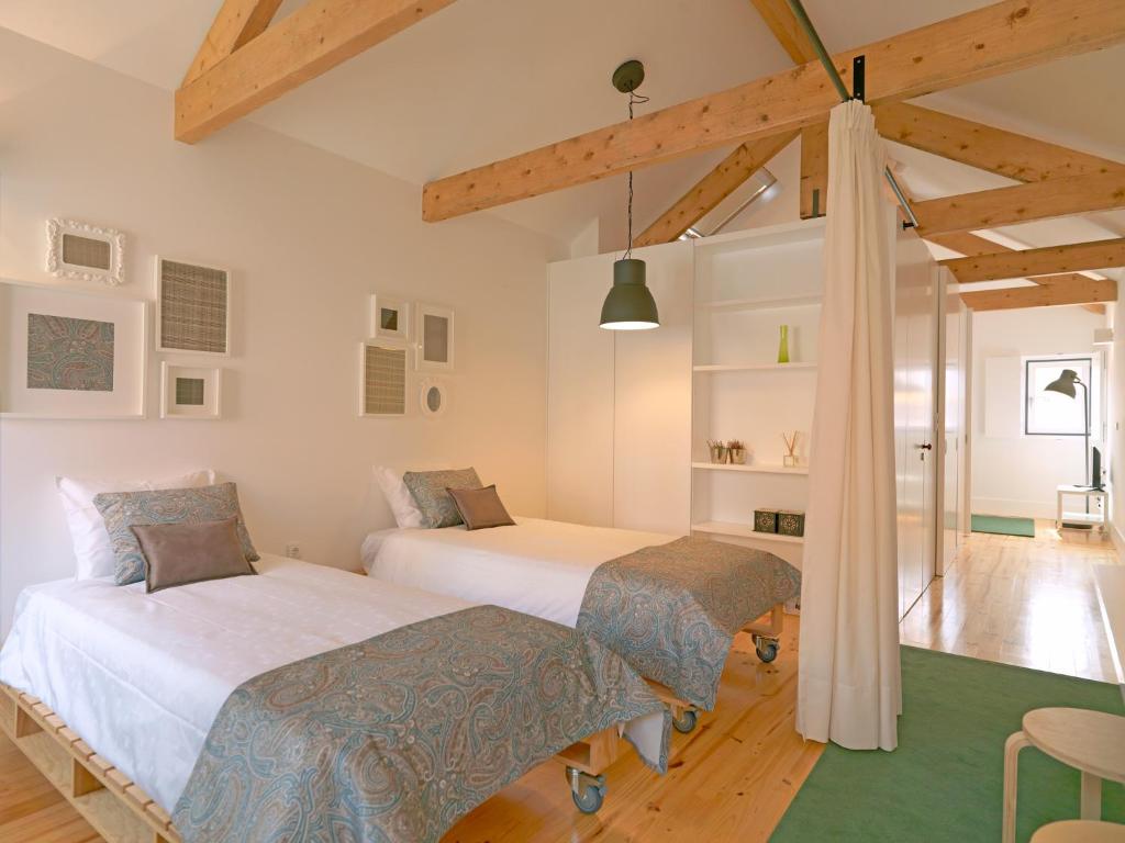 2 camas en una habitación con techos de madera en FLH Porto Modern Rooftop, en Oporto
