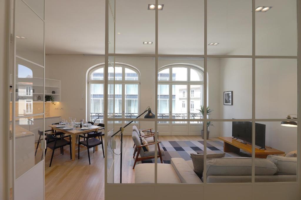 ein Wohnzimmer mit einem Tisch und einem Esszimmer in der Unterkunft FLH Sá da Bandeira Luxury Apartment in Porto