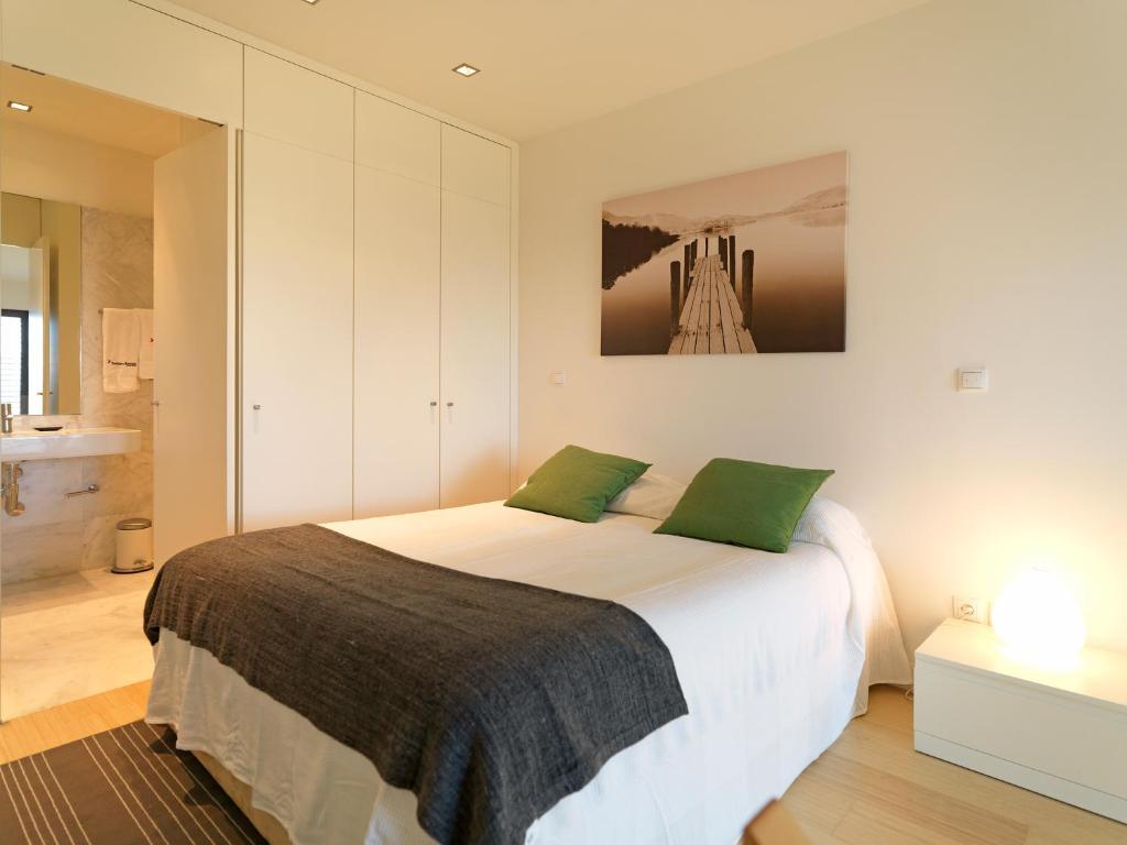 sypialnia z dużym białym łóżkiem z zielonymi poduszkami w obiekcie FLH - Porto Charming Flat w mieście Matosinhos