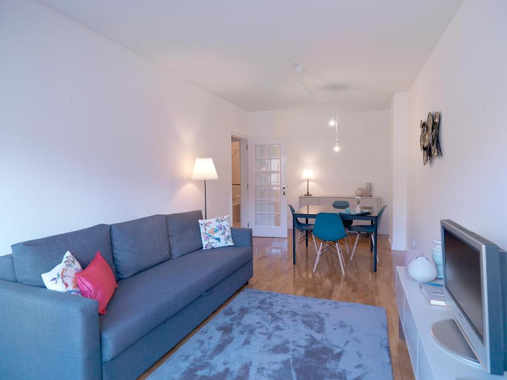 un soggiorno con divano blu e tavolo di FLH Porto Comfort Flat a Porto