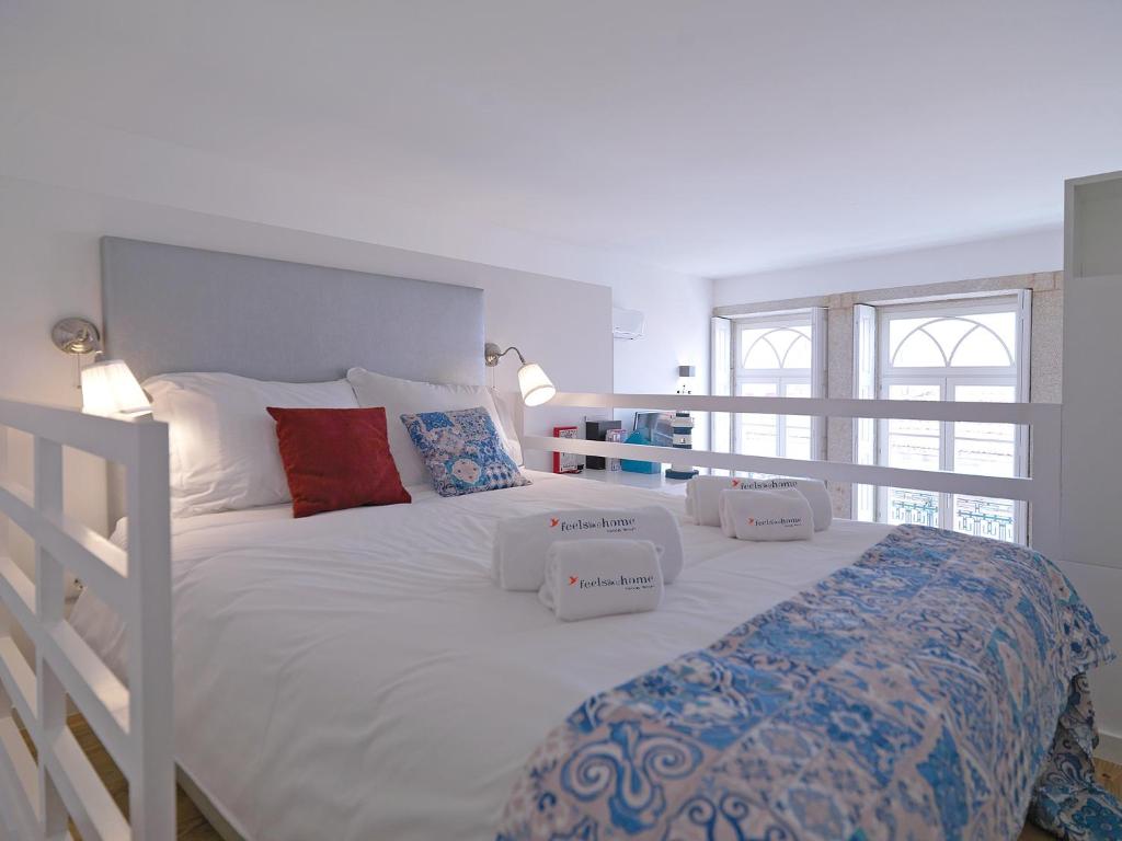 ein großes weißes Bett mit drei Kissen darauf in der Unterkunft FLH Porto Cozy Studio in Porto