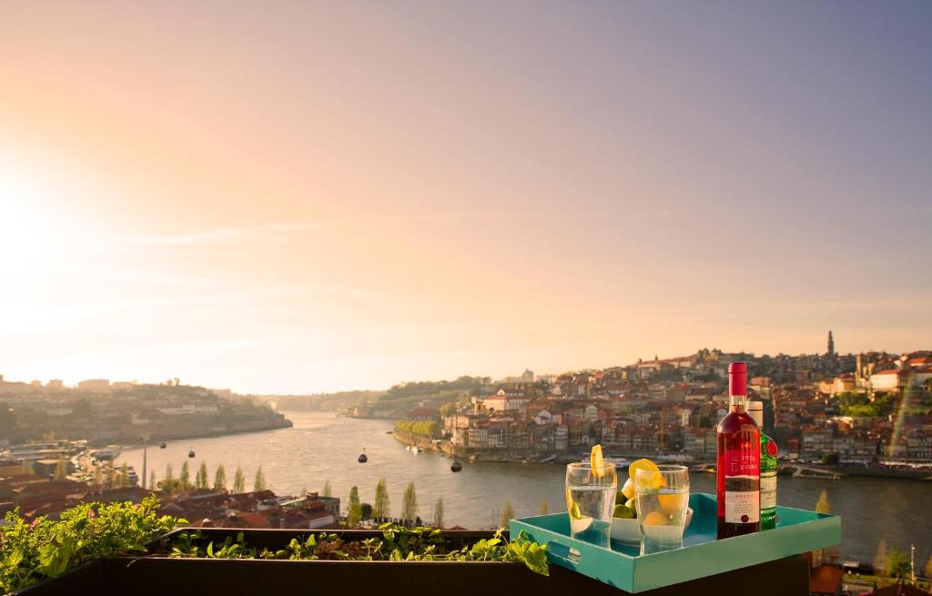 a view of a river with drinks on a ledge at FLH - Porto Vista House in Vila Nova de Gaia