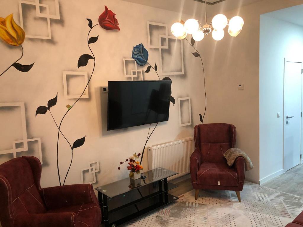 salon z 2 krzesłami i telewizorem na ścianie w obiekcie your home ! w Antwerpii