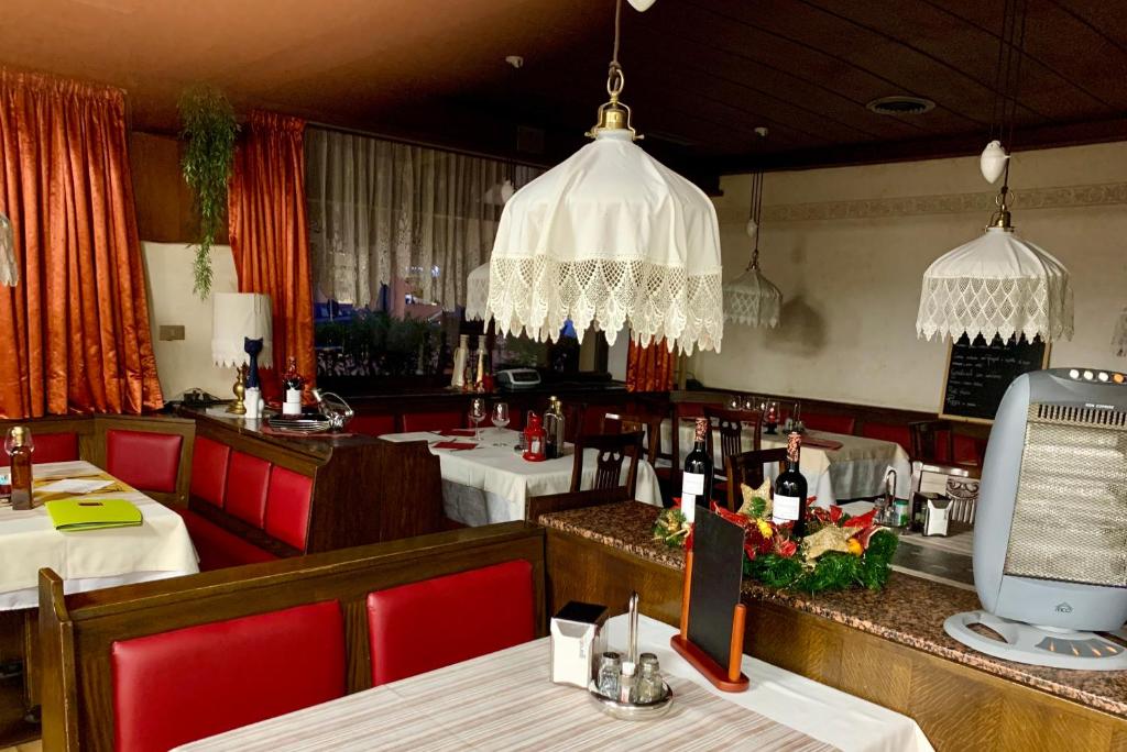 um restaurante com cadeiras vermelhas e mesas com garrafas de vinho em B&B Hotel Dolomiti em Bolzano