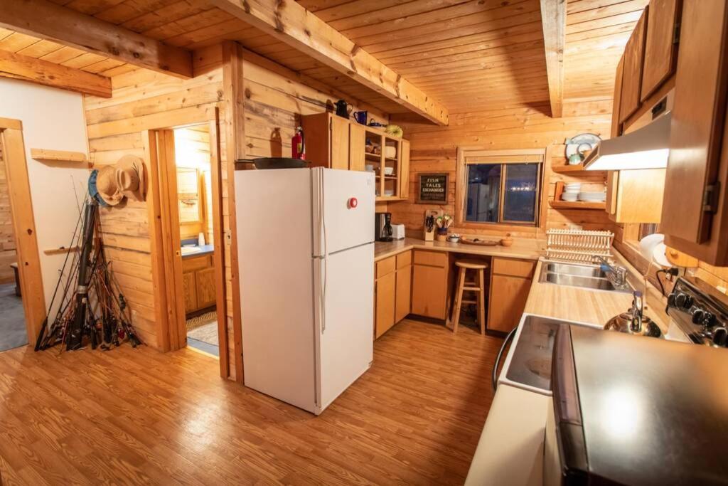 cocina con nevera blanca y paredes de madera en Premium Retreat on 450 Acres w/ Greenhouse, Meditation Room & Labyrinth, en Hillside