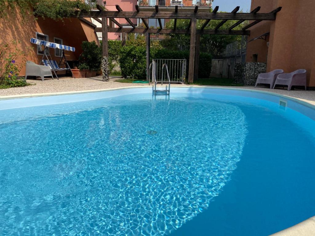duży błękitny basen z pergolą w obiekcie Welcome Traveller ALLOGGIO JAKY w mieście Garda