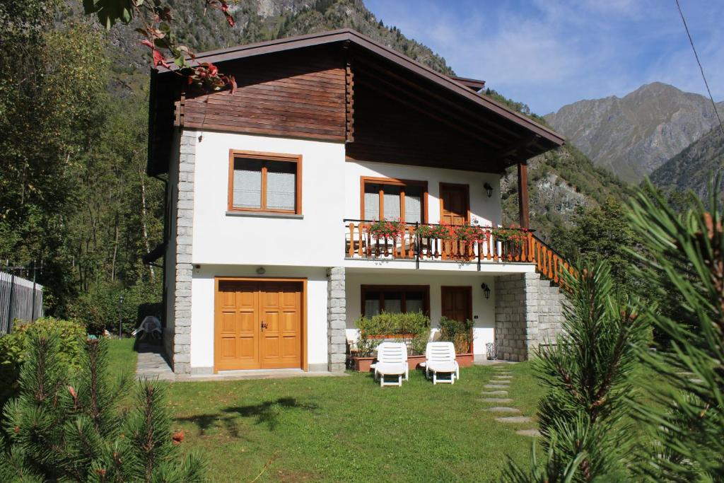 a small white house with a balcony and two chairs at Villa Egle in Antronapiana