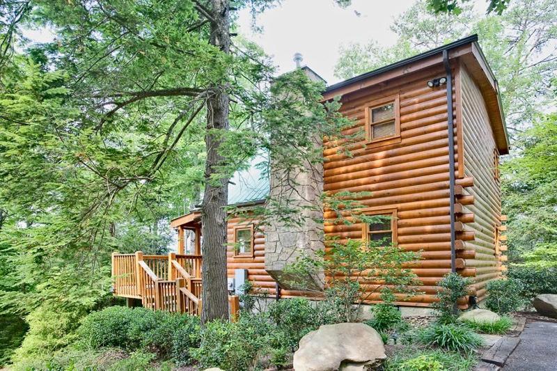 a log cabin in the woods with a deck at Sticks and Stones in Sevierville
