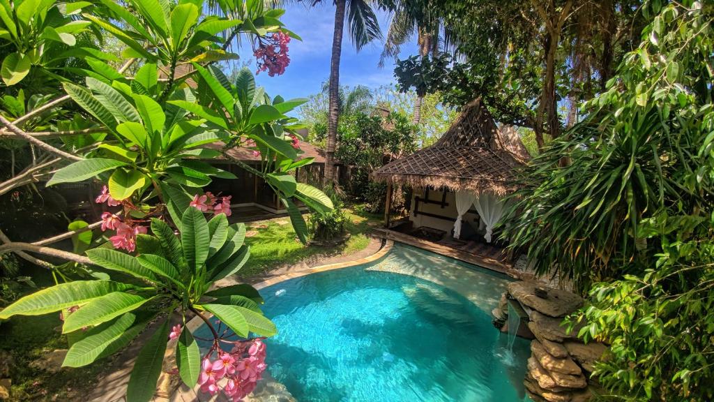 uma imagem de uma piscina em frente a uma villa em Villa Bhuvana with private swimming pool em Gili Trawangan