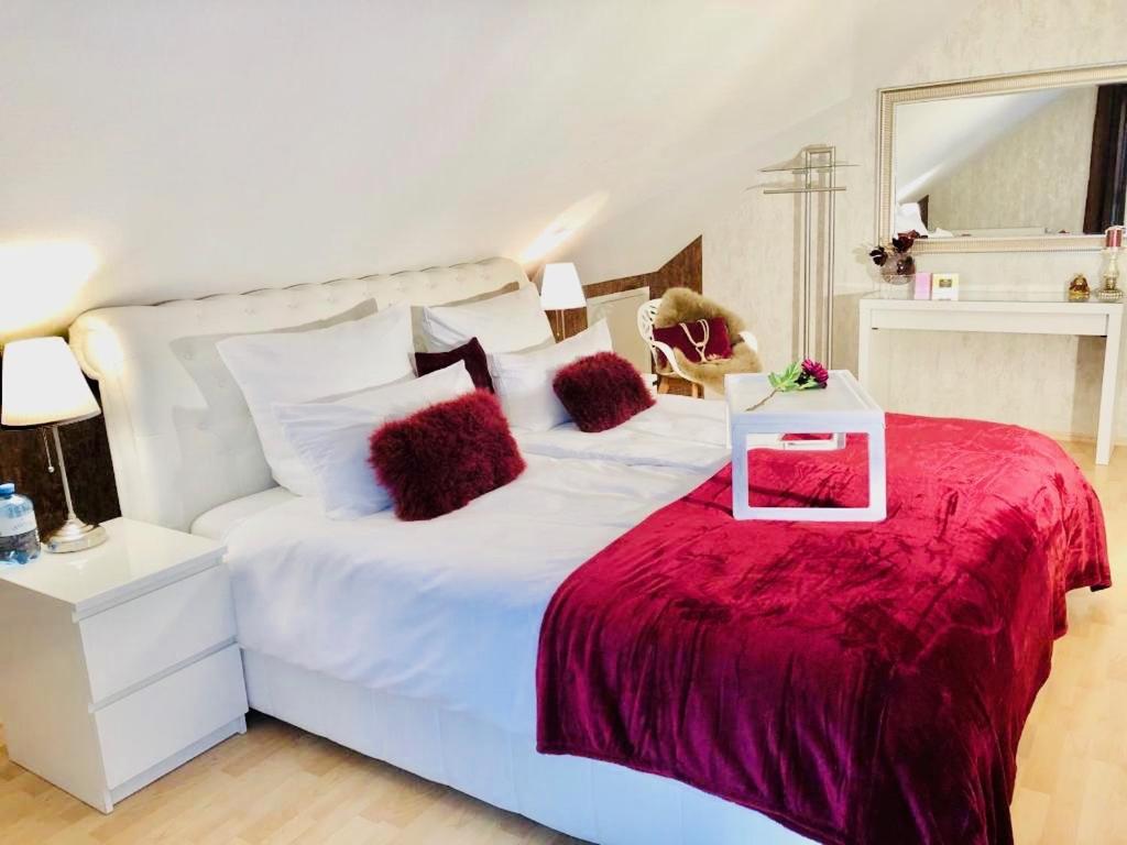 una camera con un letto bianco e una coperta rossa di Baden Airpark Family Apartment a Hügelsheim