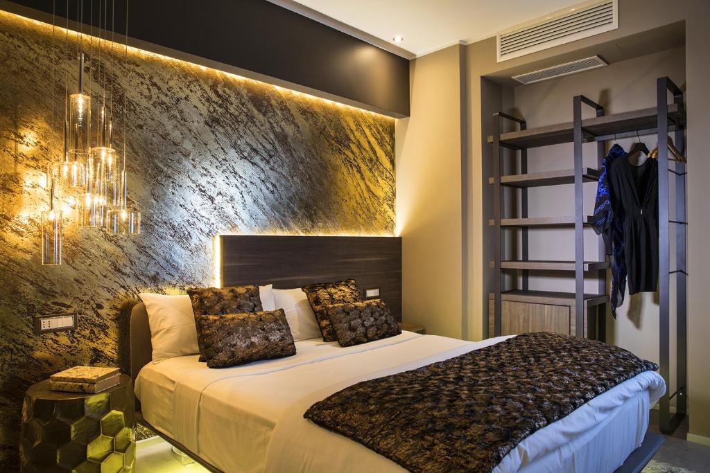 ein Schlafzimmer mit einem großen Bett und einer Wand in der Unterkunft Milestone in Quartu SantʼElena