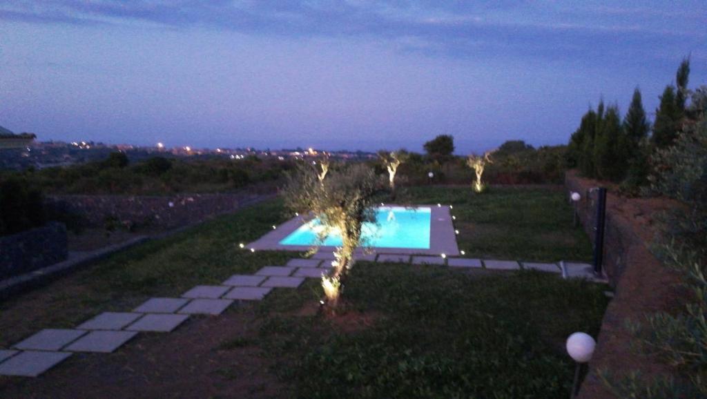 a backyard with a swimming pool at night at B&B Il Vulcano in Aci Catena