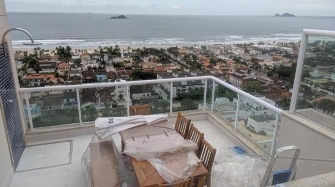 uma varanda com uma mesa e vista para o oceano em Edifício Panoramique 180 Graus, Cobertura no Guarujá