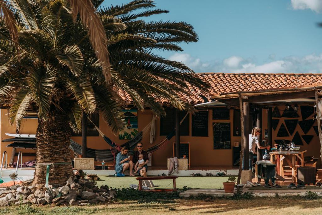 カジャオ・サルバヘにあるTwin Fin Surf Campの家の前に座る人々