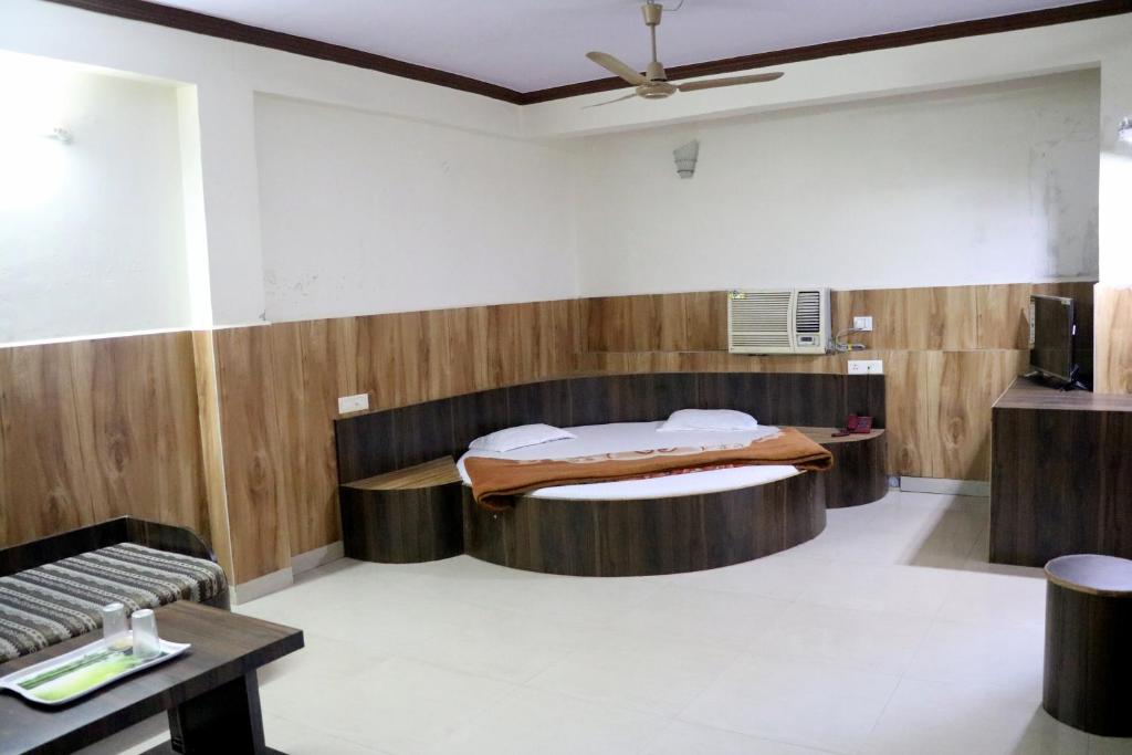Una habitación con una cama en el medio. en Jain Residency, en Pachmarhī