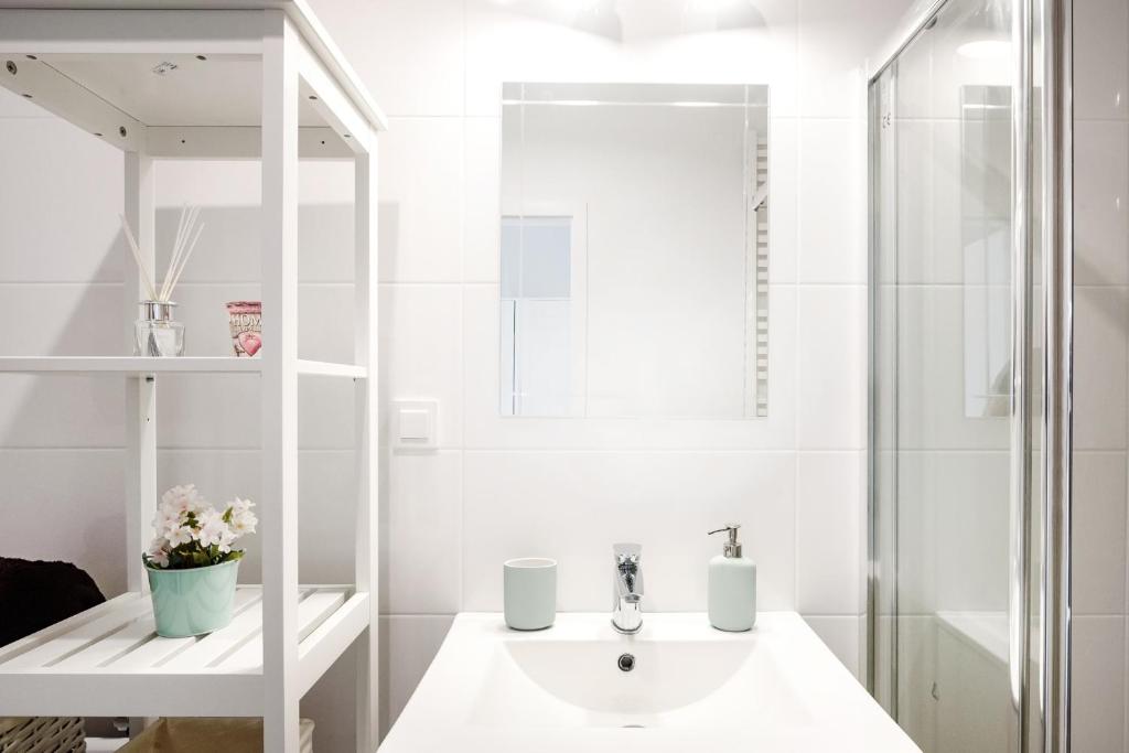 biała łazienka z umywalką i prysznicem w obiekcie M&R Apartament Airport&Business Premium Komputerowa - underground garage - free WiFi - Netflix - self check-in - 5 min from Chopin Airport w Warszawie