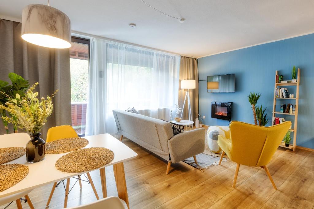 ein Wohnzimmer mit Sofa, Tisch und Stühlen in der Unterkunft Apartment Stockholm in Winterberg