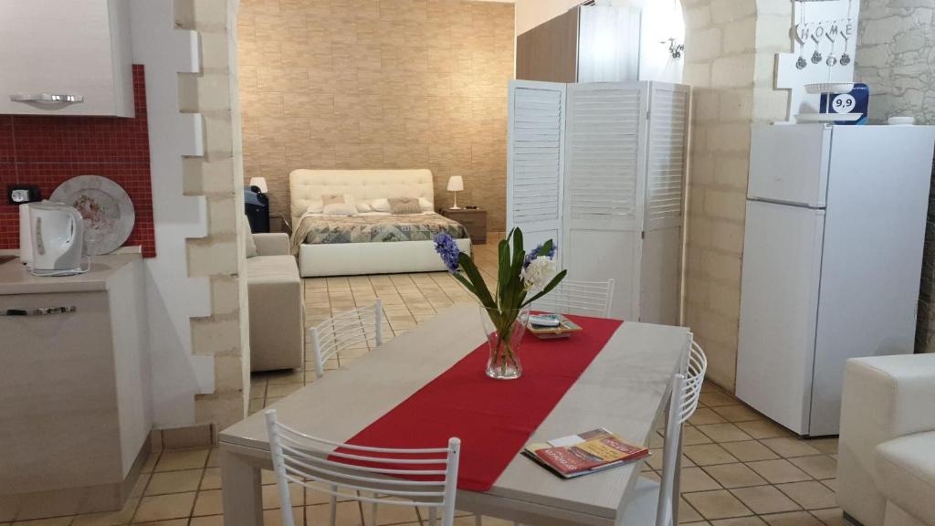 una cocina con una mesa con un jarrón de flores. en Appartamento Dammuso Isola Di Ortigia, en Siracusa