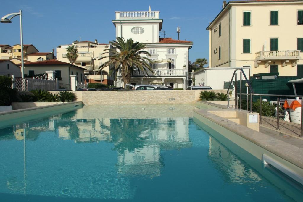 una piscina de agua azul con edificios en el fondo en Residence Villa Piani, en San Vincenzo