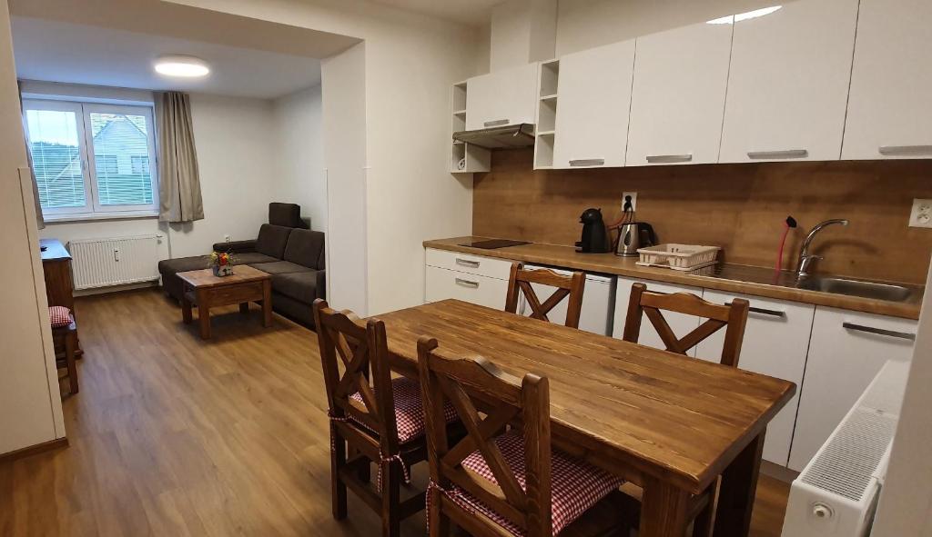 a kitchen and living room with a wooden table and chairs at Donovaly Apartments in Donovaly