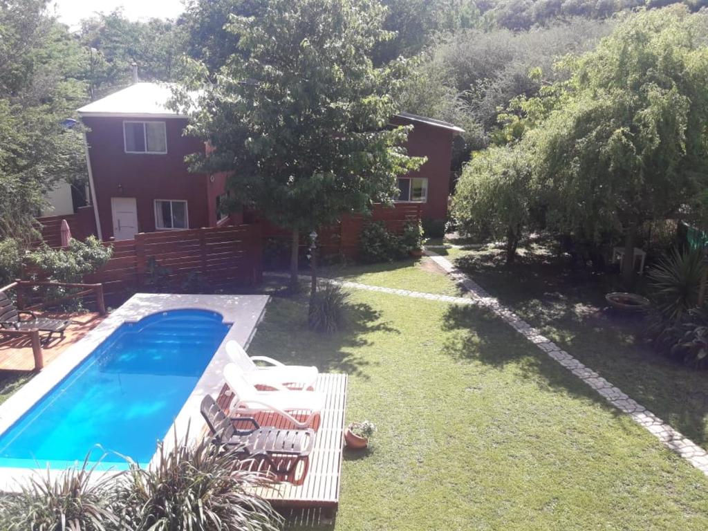 a backyard with a swimming pool and a house at cabañas La Victoria in La Falda