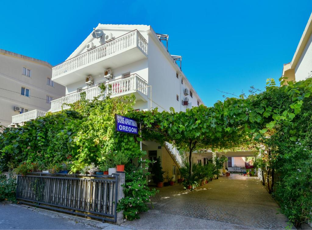 a white building with a lot of ivy at Rooms and Apartments Oregon in Budva