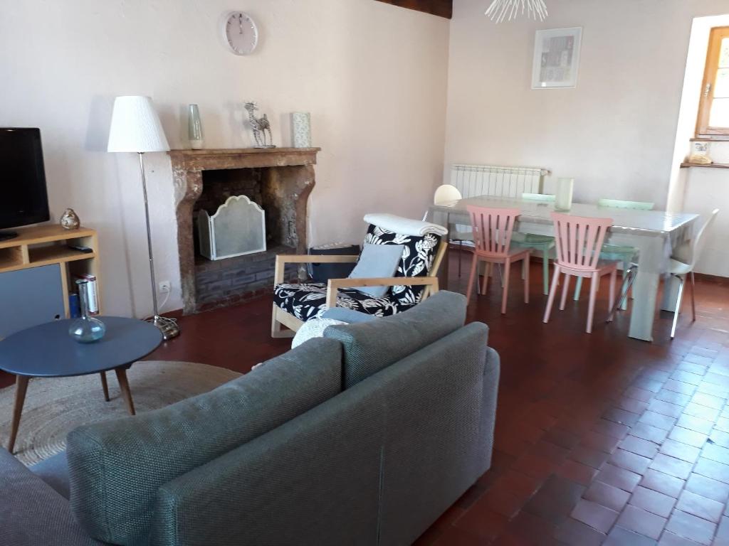 ein Wohnzimmer mit einem Sofa und einem Tisch in der Unterkunft Gite du hérisson in Saulieu