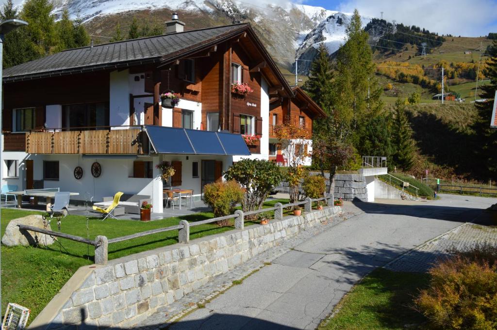 ein Haus in den Bergen mit einer Steinmauer in der Unterkunft Tgèsa Parde in Sedrun