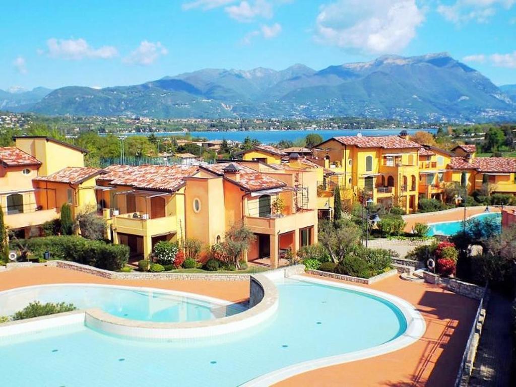 un complexe avec une piscine et des maisons dans l'établissement Borgo del Torchio E6, à Manerba del Garda