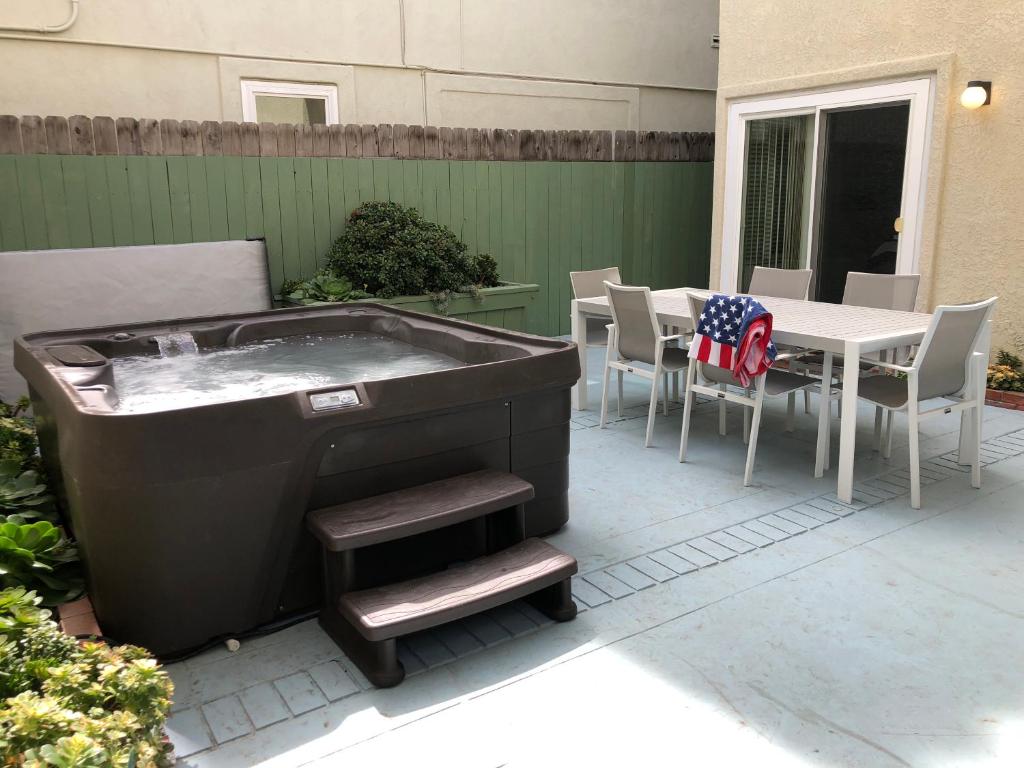a hot tub on a patio with a table and chairs at 256 Americana in Huntington Beach