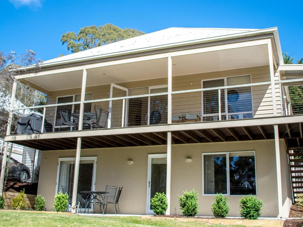 a house with balconies and tables and chairs at McMillans Villa 18 Metung in Metung