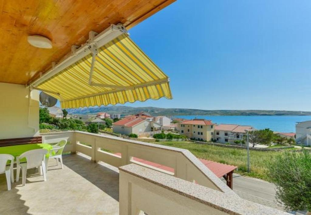 balcón con sombrilla amarilla y vistas al agua en Apartments Kosta - 150 m from beach, en Kustići