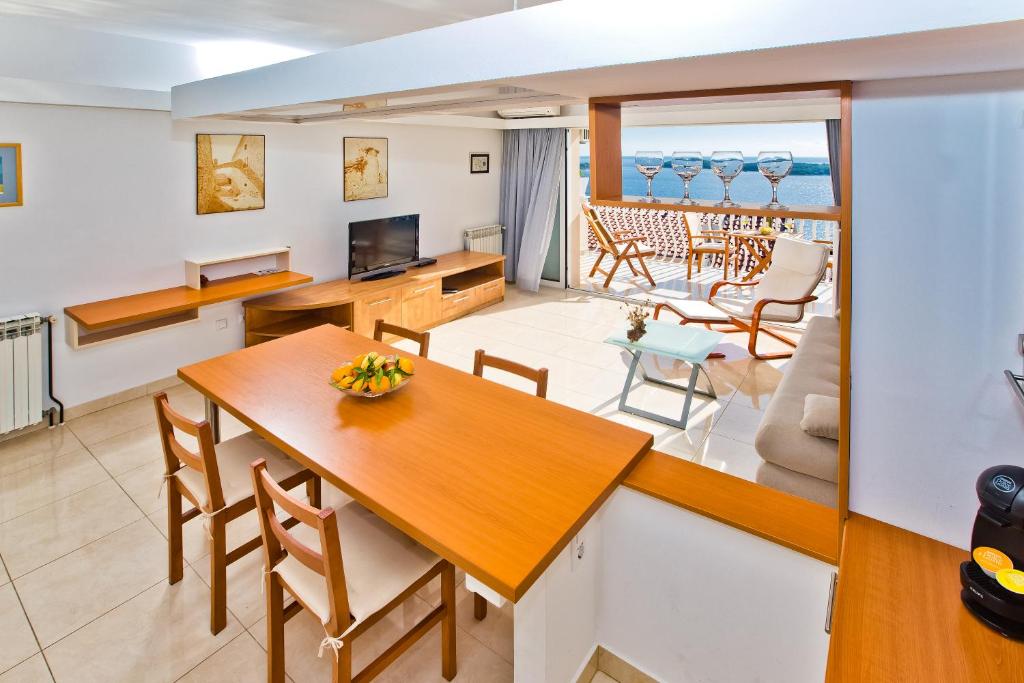a kitchen and living room with a table and chairs at Apartments Tatjana Dominis in Hvar
