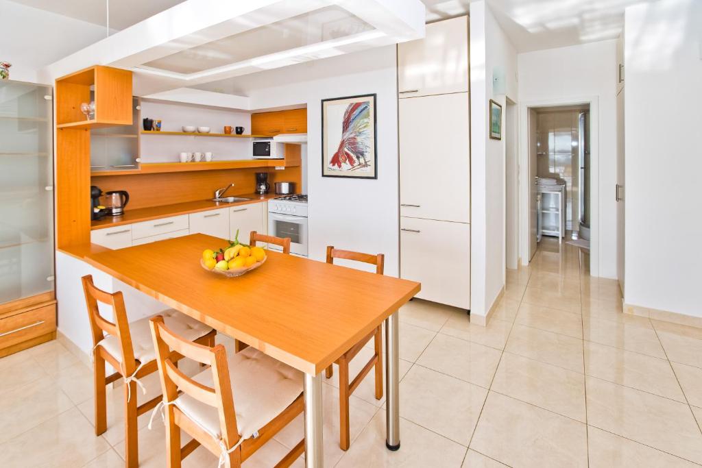 a kitchen with a wooden table and chairs at Apartments Tatjana Dominis in Hvar