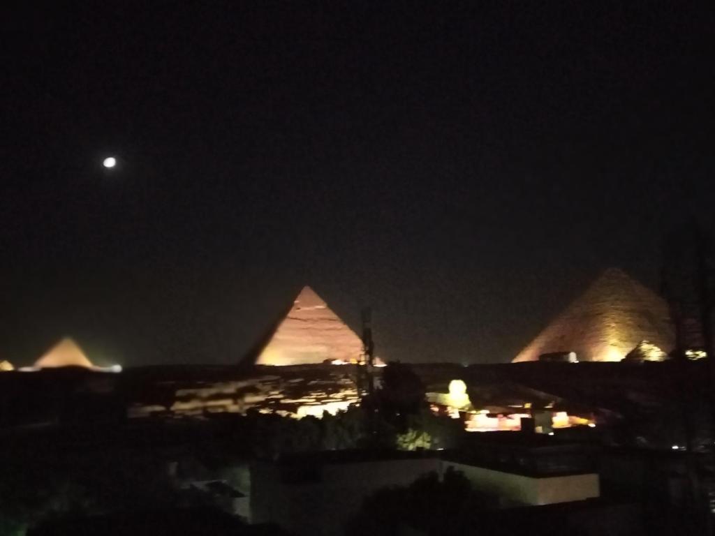 a view of the pyramids at night at Pyramids View Apartment in Cairo